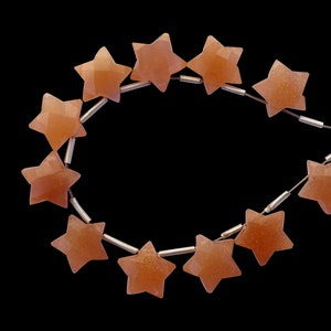 May include: A strand of orange star-shaped beads strung on a silver wire.