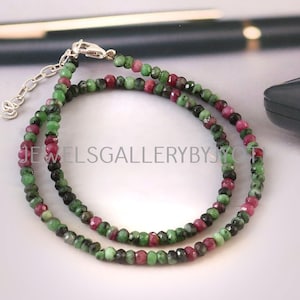 May include: A delicate necklace made with green and pink gemstone beads. The necklace is made with a silver clasp and is approximately 18 inches long.