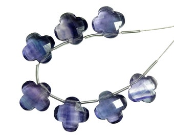 May include: A strand of purple and blue fluorite beads, each carved into a four-leaf clover shape, strung on a silver wire.