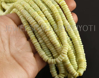 May include: A strand of light green gemstone beads. The beads are faceted and have a round shape. The beads are strung on a clear thread.