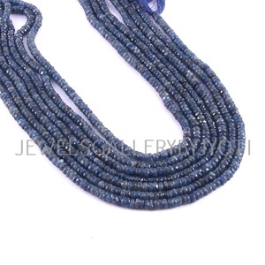 May include: A strand of blue sapphire beads, with a faceted, slightly irregular shape. The beads are strung on a thread and are ready to be used for jewelry making.