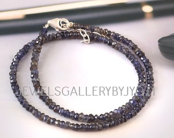 May include: A double strand necklace made of small, faceted, dark blue gemstones. The necklace has a silver clasp.
