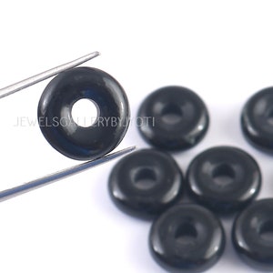 May include: Black onyx donut beads with a smooth, polished finish. The beads have a hole in the center for stringing.