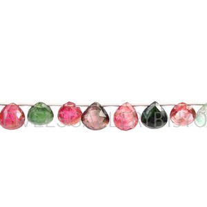 May include: A strand of faceted gemstone beads in various colors, including green, pink, yellow, and black. The beads are strung on a silver wire.