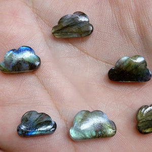 Peut inclure: Six cabochons de labradorite irisés taillés en forme de nuages. Les cabochons sont un mélange de gris foncé, de bleu et de vert.