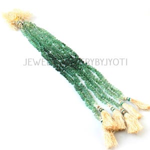 May include: Strands of green gemstone beads with a gradient effect, transitioning from dark to light green. Each strand is finished with a tassel. The text "JEWELRYBYJYOTI" is visible.