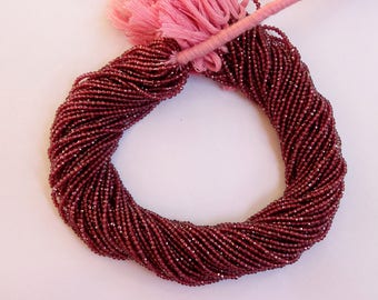 May include: A strand of deep red garnet beads, approximately 4mm in size, with a faceted finish. The beads are strung on a thin thread and are ready for jewelry making.