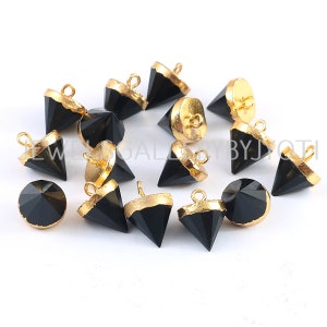 Könnte beinhalten: Schwarze Edelstein-Pyramidenanhänger mit goldenen Akzenten. Jeder Anhänger hat eine Öse zum Anbringen an Schmuck.