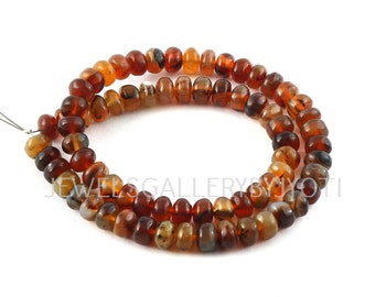 May include: A strand of brown, orange, and white carnelian beads. The beads are round and have a smooth, polished finish.