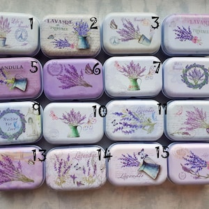 Può includere: Sedici piccole scatole rettangolari in metallo con disegni floreali di lavanda. Ogni scatola ha un design e un testo diversi, tra cui "How's Life", "Lavande de Provence", "Waiting for Love" e "Lavander".