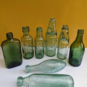 Collection of medium sized antique bottles in a variety of shapes, poison bottle, codd bottle, tornado bottle