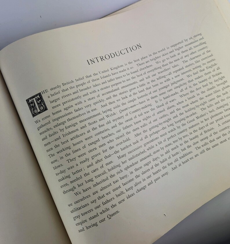May include: A vintage book with a brown cover and gold lettering. The title of the book is "Introduction". The text on the page discusses the beauty of the United Kingdom and its history.