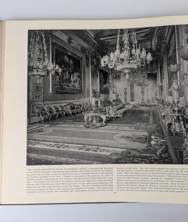 May include: A black and white photograph of a grand reception room in Windsor Castle. The room is decorated in the style of Louis XIV, with ornate chandeliers, a large fireplace, and a patterned carpet. The room is furnished with chairs, sofas, and tables.