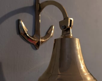 Large brass anchor bell with rope, wall mounted bell