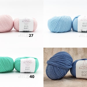 May include: Four skeins of yarn in different colors: pink, light blue, green, and blue. Each skein has a label that reads "Laines du Nord Eco Baby Luxury Line".