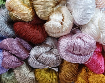 May include: A collection of colorful embroidery floss spools in various shades of purple, pink, blue, green, red, gold, and white.