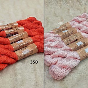 以下が含まれることがあります： 赤い糸とピンクの糸の刺繍糸が2つ巻かれた糸巻き。糸巻きには350と343の番号が付けられています。