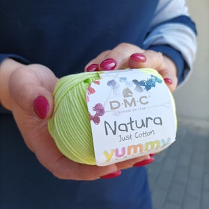 May include: A ball of light green yarn with a label that reads "DMC Natura Just Cotton Yummy Colors" and a small horse logo.