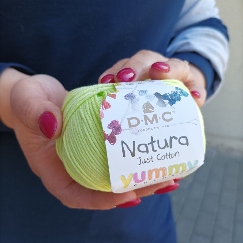 May include: A ball of light green yarn with a label that reads "DMC Natura Just Cotton Yummy Colors" and a small horse logo.