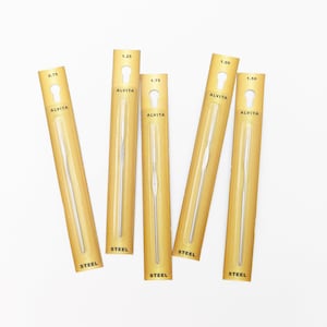 May include: Six individually packaged steel crochet hooks in sizes 0.75, 1.00, 1.25, 1.50, and 1.75 mm. Each package is gold with black text that reads "ALVITA" and "STEEL".