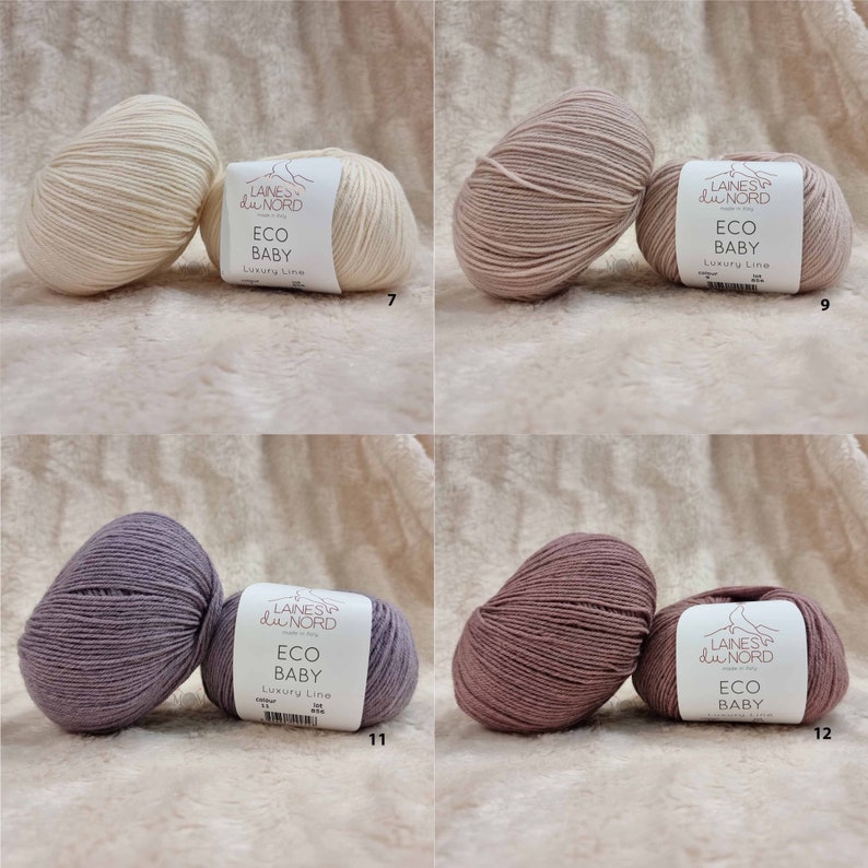 May include: Four skeins of yarn in different colors: white, light pink, purple, and pink. Each skein has a label that reads "Laines du Nord Eco Baby Luxury Line".