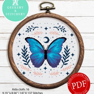 May include: Cross stitch pattern featuring a blue butterfly with a crescent moon and floral accents. The pattern is 9.19 inches by 8.56 inches and uses 7 DMC thread colors. The pattern is available as a PDF download.