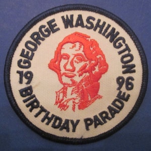 May include: A white and black circular patch with a red embroidered image of George Washington. The text "1979 Birthday Parade 1979" is written around the image.