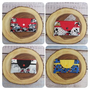 May include: Four different Mickey Mouse themed zippered pouches with red, black, and yellow accents. Each pouch has a different Mickey Mouse print fabric.