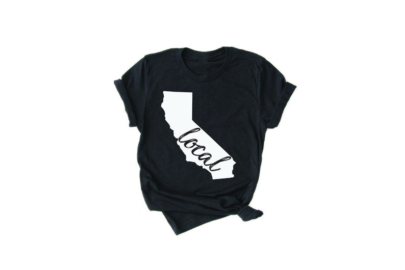 May include: A black t-shirt with a white outline of the state of California and the word "local" written inside the outline.