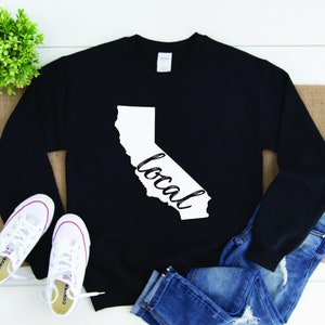 May include: Black sweatshirt with a white outline of the state of California and the word "local" written inside the outline.