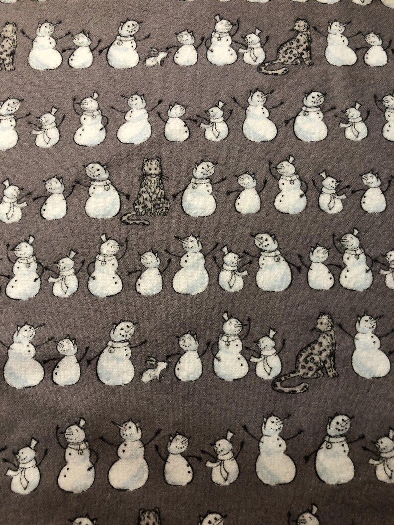 K&ouml;nnte beinhalten: Ein sich wiederholendes Muster auf grauem Hintergrund mit Schneem&auml;nnern mit ausgestreckten Armen, jeweils gepaart mit einem kleineren Schneemann. Dazwischen befinden sich Illustrationen von Katzen und Kaninchen. Die Schneem&auml;nner haben schwarze Arme und Karottennasen.