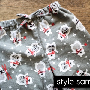 Puede incluir: Pantalones de pijama grises con un estampado repetido de osos polares blancos con bufandas rojas y bastones de esqu&iacute; rojos. Los pantalones tienen una cintura con cord&oacute;n y las palabras "style sample" est&aacute;n impresas en la parte inferior derecha.
