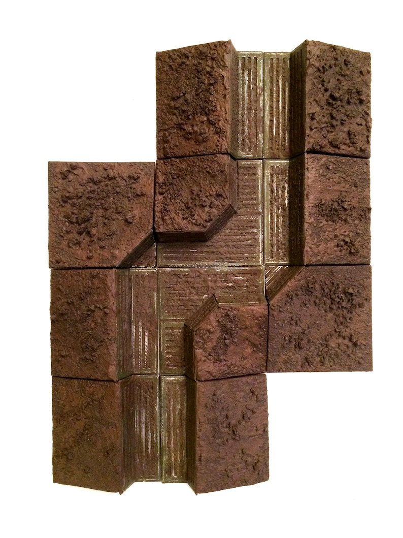 Pode incluir: Um conjunto de azulejos texturados marrons e cinzentos com um design em relevo. Os azulejos s&atilde;o dispostos em um padr&atilde;o para criar um caminho ou uma passarela.