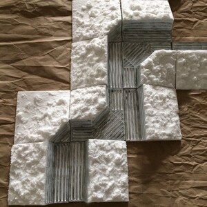 May include: A set of white foam tiles with a gray textured pattern. The tiles are arranged in a pattern that resembles a path or a maze.