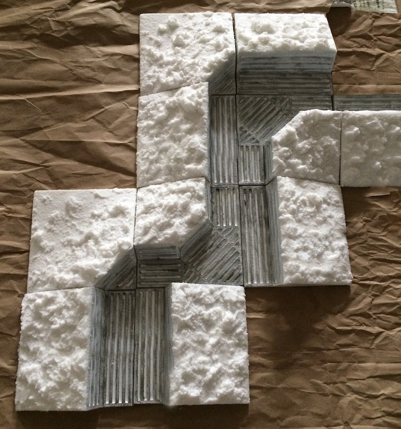 May include: A set of white foam tiles with a gray textured pattern. The tiles are arranged in a pattern that resembles a path or a maze.