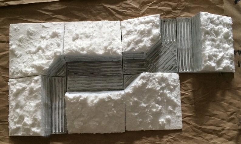 May include: A set of eight white textured tiles with a gray textured center section. The tiles are arranged in a rectangular shape, with the gray center section forming a square.
