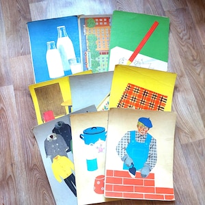May include: A collection of vintage children's book covers. The covers feature illustrations of milk bottles, buildings, a red pencil, a plaid pattern, coats, a blue pot, and a bricklayer. The books are arranged on a wooden surface.