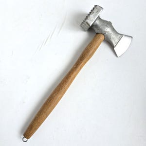 May include: A meat tenderiser with a wooden handle and a metal head. The head has a textured side for tenderising and a flat side for flattening. A small metal loop is at the end of the handle.