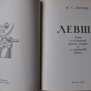 May include: A black and white illustration of a blacksmith's anvil and hammer. The book cover features the title "LEVSHA" in large, bold letters and the text "Skaz o tul'skom kosom levshe i o stal'noy blohe" in smaller font. The book was published in Moscow in 1973.