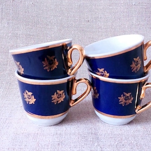 Peut inclure: Ensemble de quatre tasses à thé bleues et dorées avec un motif floral. Les tasses sont empilées les unes sur les autres.