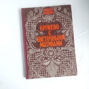 May include: A hardcover book with a brown cover featuring white lace-like patterns and text in orange. The book's spine is a deep red. The title and author's name are visible on the cover.