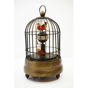 May include: A brass birdcage clock with three small birds inside. The clock face is visible through the cage and the birds are moving.