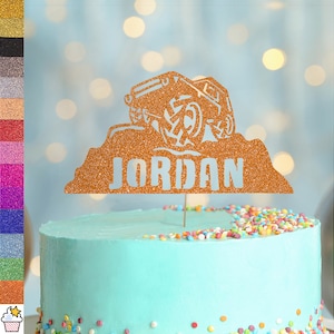 Può includere: Topper per torta in glitter dorati con una silhouette di una jeep che guida su una collina. Il nome "JORDAN" è scritto sotto la jeep.