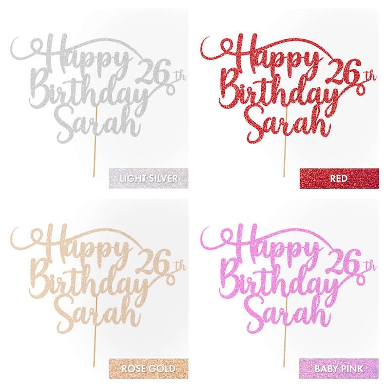 May include: Four cake toppers with the text "Happy 26th Birthday Sarah" in different glitter colors: light silver, red, rose gold, and baby pink.