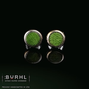 May include: A pair of circular stud earrings featuring a bright green textured center inlay surrounded by a polished silver-tone metal rim. The text :BURHL ARTISAN CRAFTED ACCESSORIES PROUDLY HANDCRAFTED IN USA is visible in the bottom left corner.