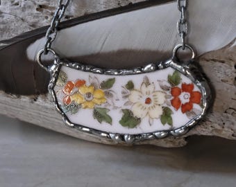 Pendentif en porcelaine cassée, motif floral vintage rouge, blanc et jaune, patine gris anthracite, collier soudé fait main et recyclé.