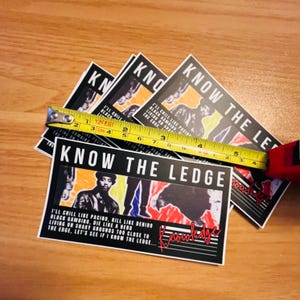 May include: A white ceramic mug with a black handle and the text "But First, Coffee" in a black, bold font. The mug is sitting on a white surface. The mug is approximately 4 inches tall.