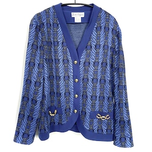 May include: A blue cardigan with a chain pattern and gold buttons. The cardigan has a V-neck and long sleeves. The label reads "Gianni Versace".
