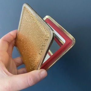 Vintage square shaped compact mirror with copper gold exterior.
