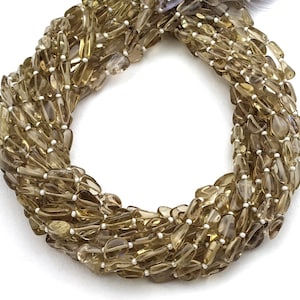 May include: A strand of brown smoky quartz gemstone beads, each bead is a teardrop shape with a faceted finish. The beads are strung on a clear thread.